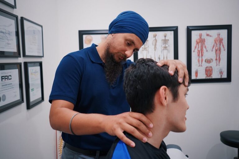 Professional physiotherapist adjusting a patient's neck in a medical office.