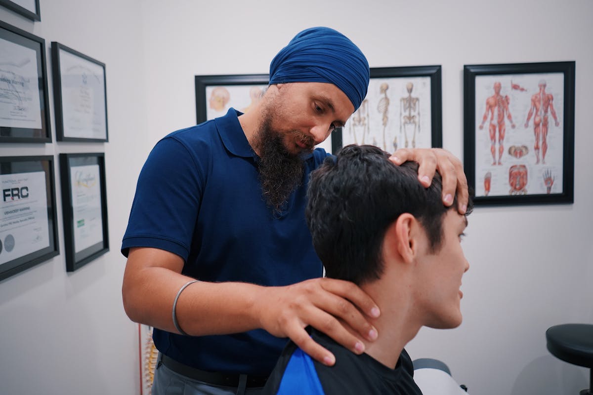 Professional physiotherapist adjusting a patient's neck in a medical office.